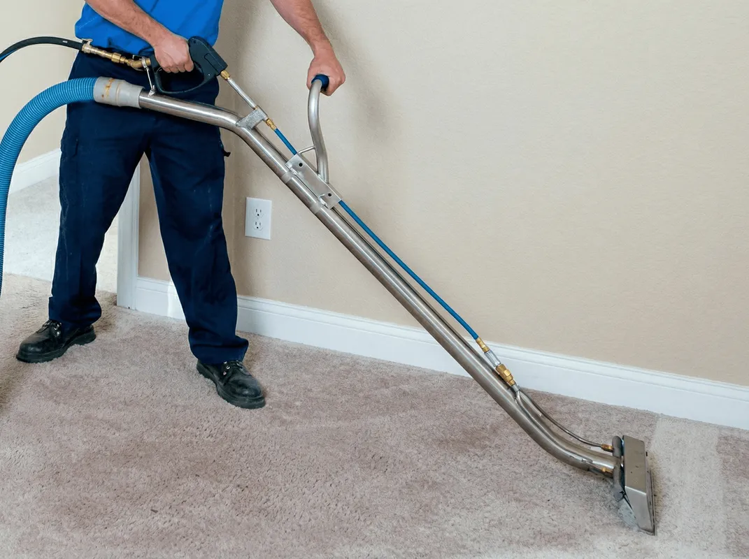 Professional operating a liquid removal machine on a carpeted floor in Rochester, NY